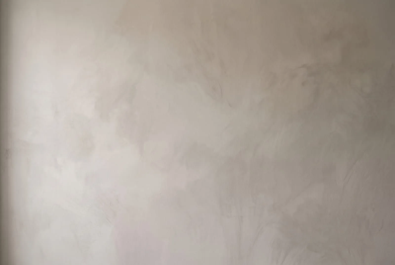 A close-up of a limewashed wall showing soft, cloudy, matte tone variation