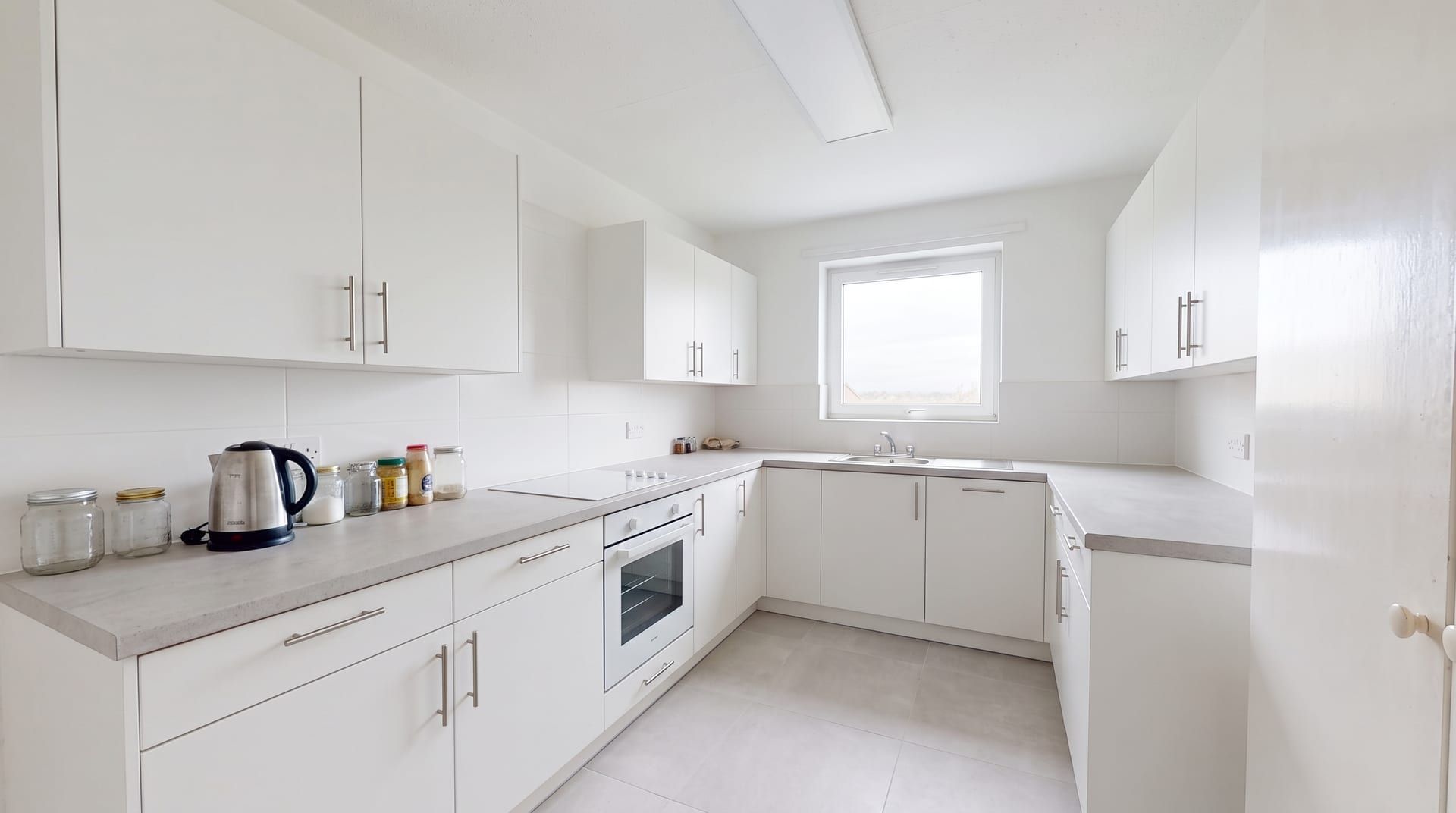The same small kitchen redesigned in a Modern style, with its windows, walls and camera angle unchanged