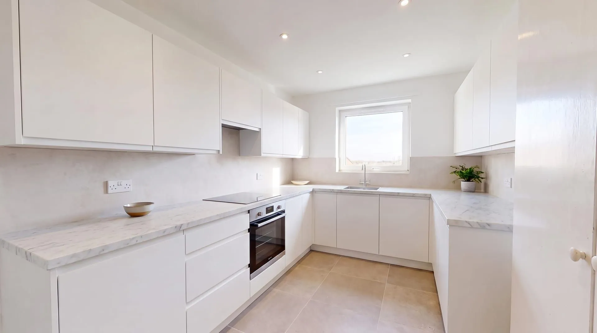 The same kitchen with a honed white Carrara marble countertop with soft grey veining